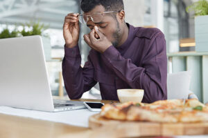 Probably overworked man sitting in front of a laptop